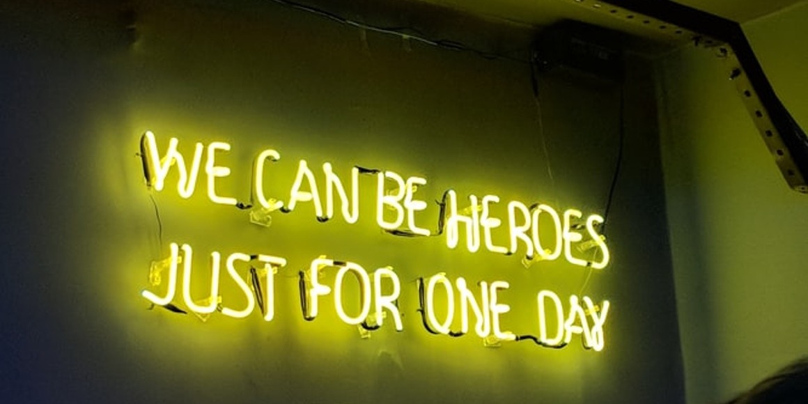 neon sign saying "we can be heroes just for one day"